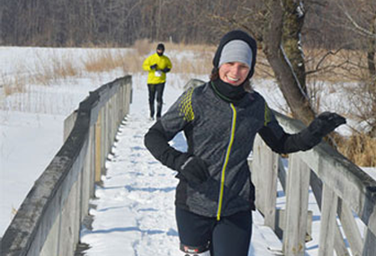 Woman running on snow with icespikes