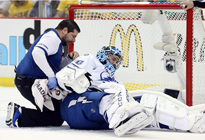 hockey medic using icespikes for traction on ice in hockey ring